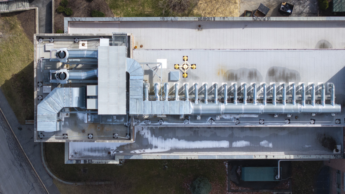 Rooftop mechanical system with ducts, fans, and ventilation equipment seen from above.