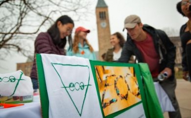 Students tabling on ho plaza stand behind a sign for the club "ECO"