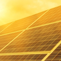 Solar panel with sun beating down on it.