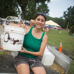 Student sitting on truck holding a compost bucket