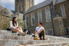 Two students sit outside and talk