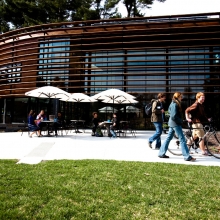 People outside of the Nevin Welcome Center at Cornell Plantations enjoying the sunny day. 